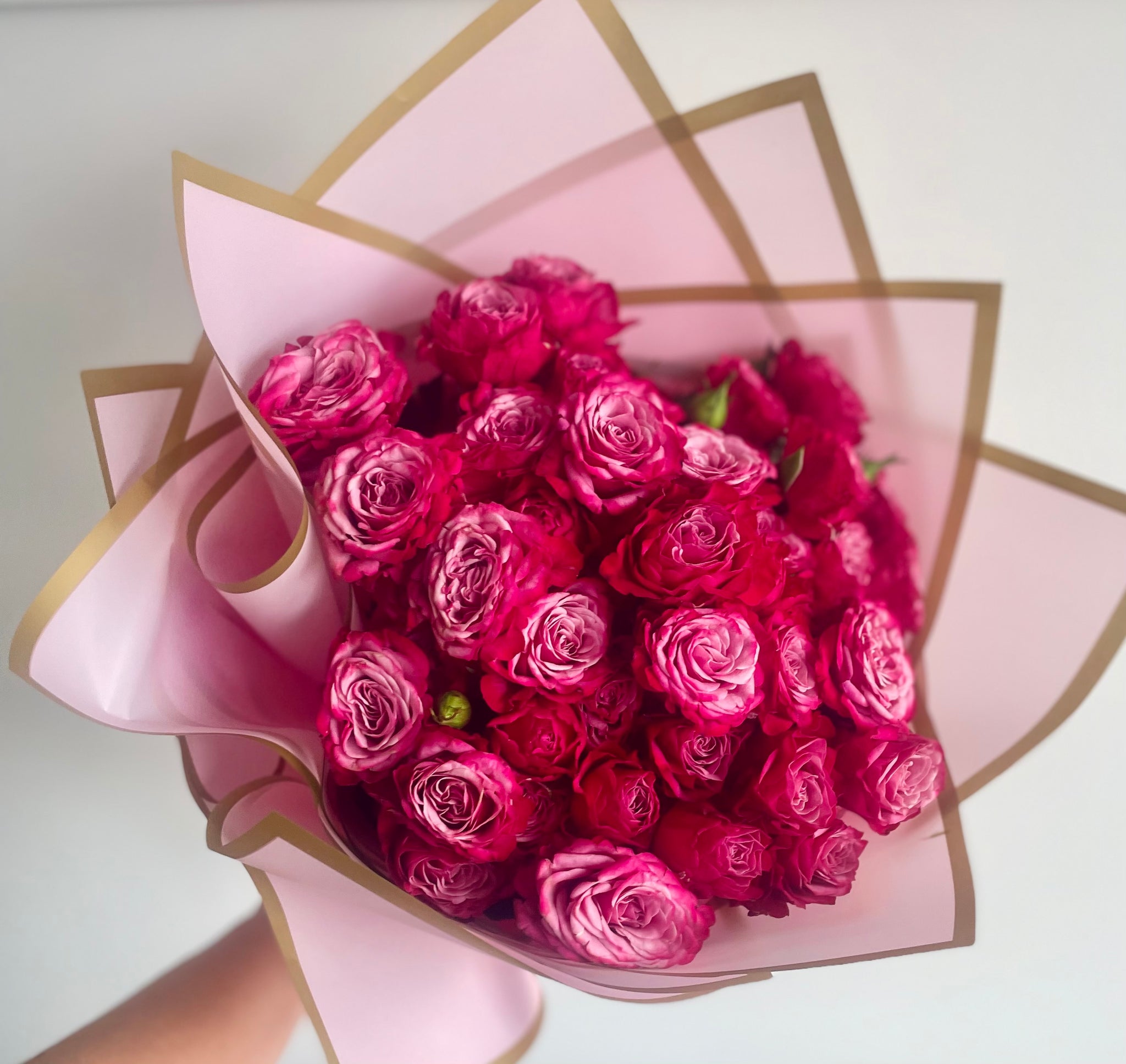 Lucky Dip bouquet of fresh roses in assorted colours, hand-tied and wrapped in kraft paper with a satin ribbon.